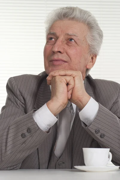 Smiling elderly man sits — Stock Photo, Image