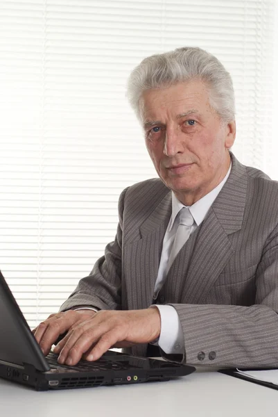 Dojrzały człowiek siedzi na laptopie — Zdjęcie stockowe