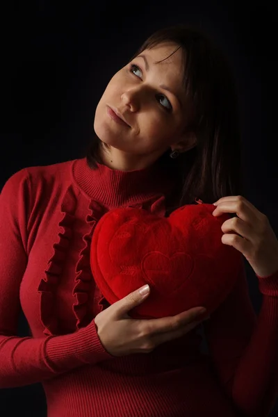 Pretty Caucasian woman with a happy heart pillow — Stock Photo, Image