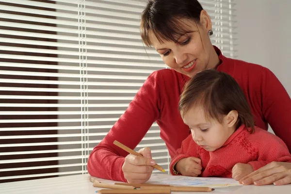 Bella caucasica felice mamma con una figlia disegnare con matite — Foto Stock
