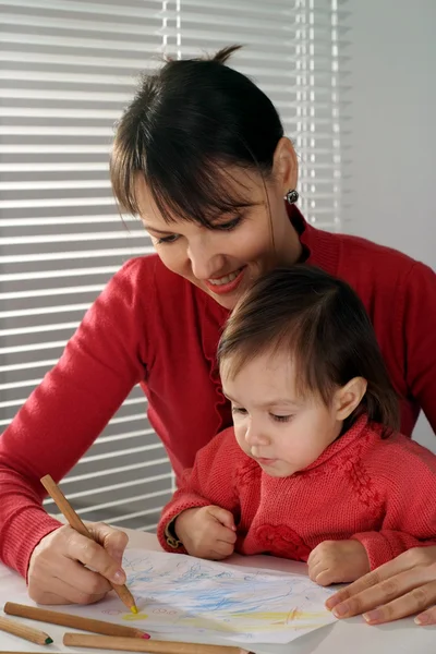 Pretty Caucasian happy mom with a daughter draw with pencils — Stock Photo, Image