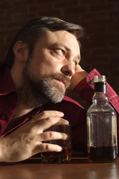 Kaukaski mężczyzna z posiedzenia butelką — Zdjęcie stockowe