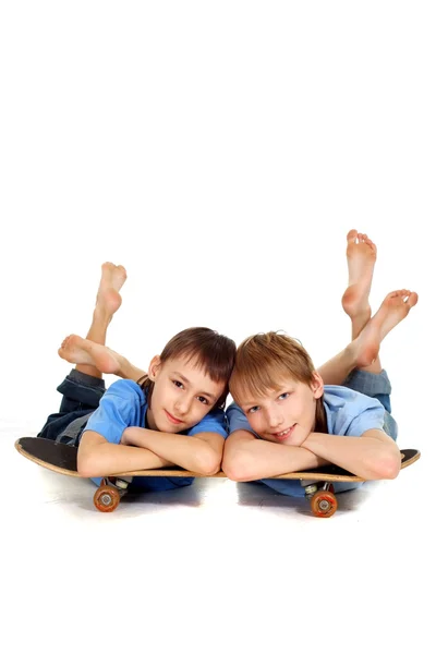 Zwei Jungen posieren auf einem Skateboard — Stockfoto