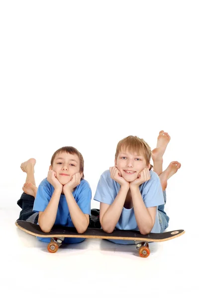 Dois meninos posando em um skate — Fotografia de Stock