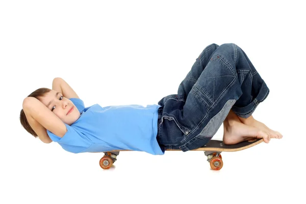 Niño acostado en un monopatín — Foto de Stock