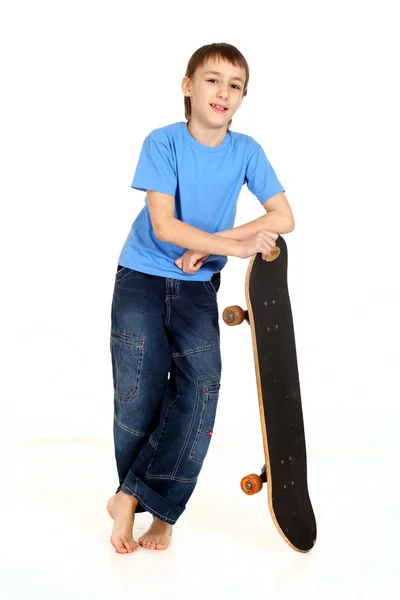 Jongen leunend op skateboard — Stockfoto