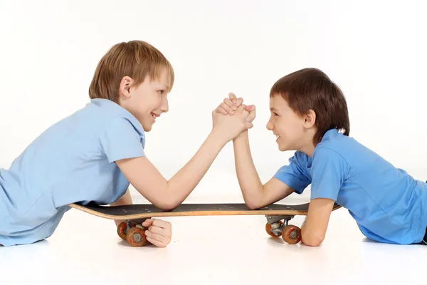 Deux garçons se battent sur un skateboard — Photo