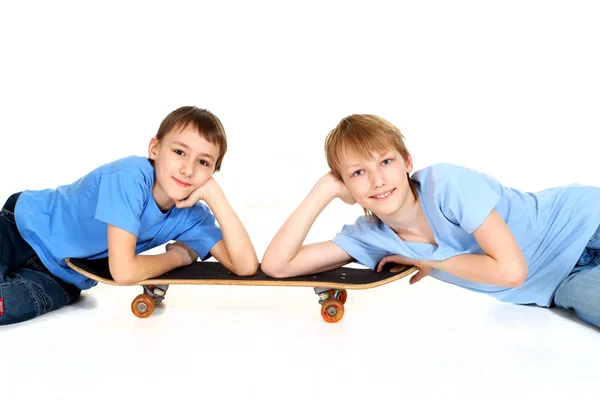 Dois rapazes deitados no skate — Fotografia de Stock