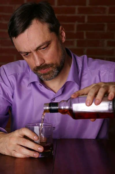 Muž s whisky u stolu — Stock fotografie