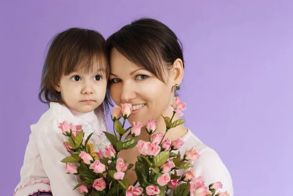 Schöne kaukasische Hündin mit einer Tochter und Blumen — Stockfoto