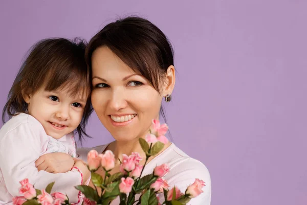 Bella femmina caucasica con una figlia e fiori — Foto Stock