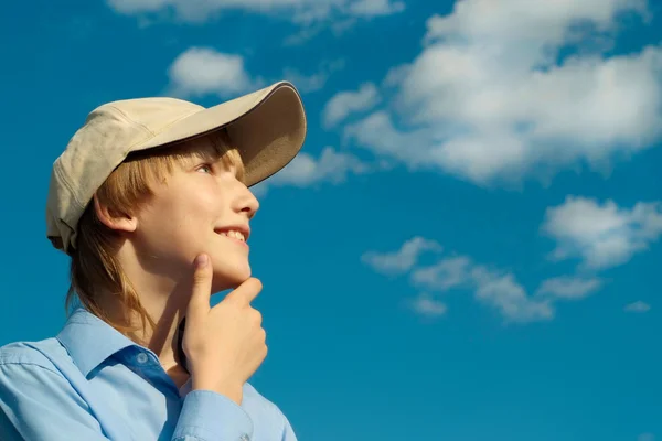 Teen in a cap under a blue sky — Stock Photo, Image