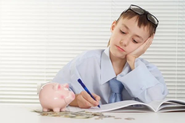 Een jonge Kaukasische gelukkig business man zit aan de tafel en wr — Stockfoto