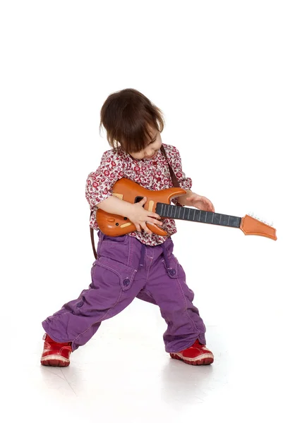 Linda menina feliz brinca com uma guitarra — Fotografia de Stock