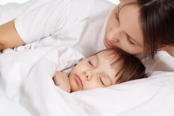 Klein meisje liggend op bed thuis — Stockfoto