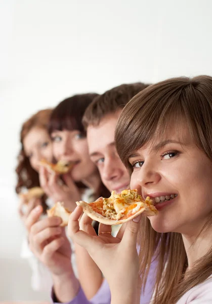 Jongen en charmante meisjes eten de pizza — Stockfoto