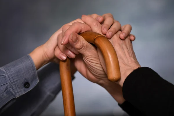 Jonge handen met handen grootmoeder — Stockfoto