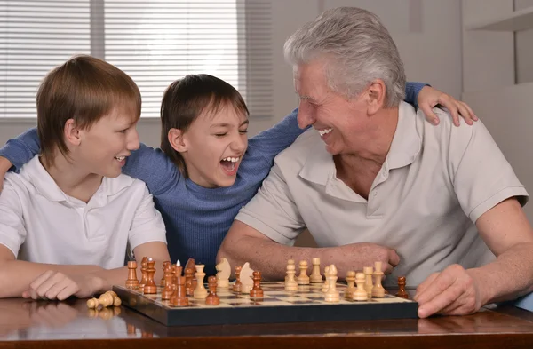 Två pojkar och farfar spelar schack — Stockfoto