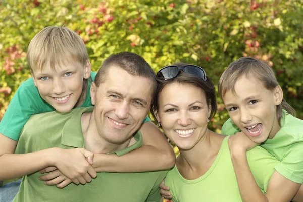 Família amigável em camisas verdes — Fotografia de Stock