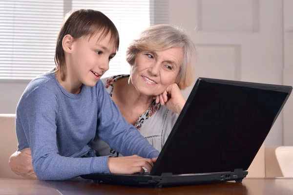 Menino e avó com laptop — Fotografia de Stock