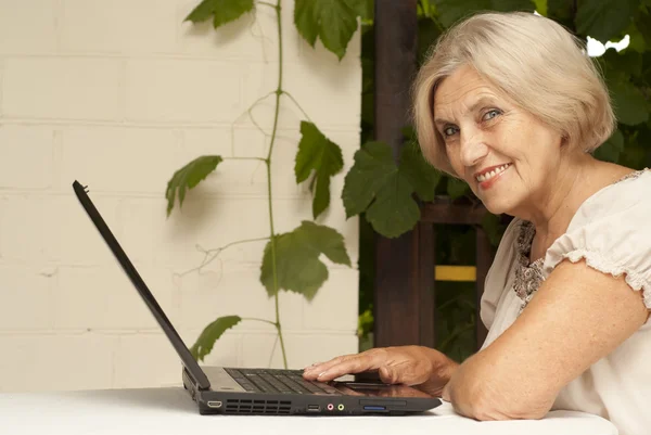 Smart äldre kvinna sitter på verandan — Stockfoto