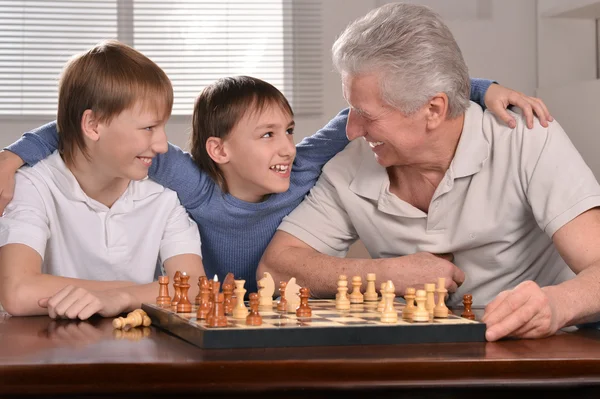 Two boys and grandfather playing chess — Stock Photo, Image