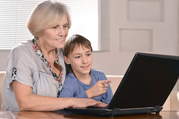Menino e avó com laptop — Fotografia de Stock