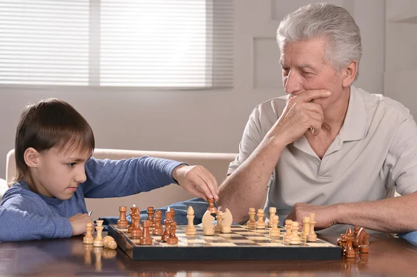 Pojke och farfar spelar schack — Stockfoto