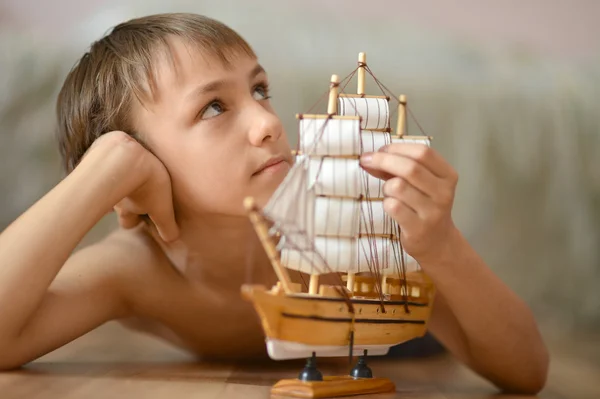 Bambino con una nave giocattolo — Foto Stock