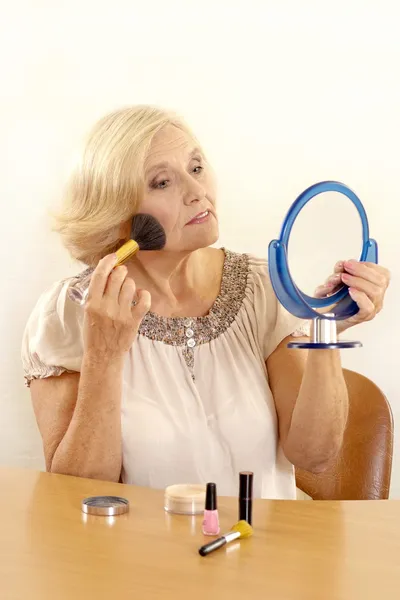 Mature woman makes her makeup — Stock Photo, Image