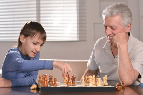 Pojke och farfar spelar schack — Stockfoto