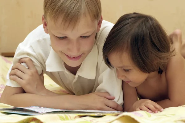 Niño y niña leyendo un libro — Foto de Stock