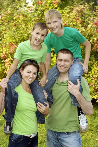 Família amigável em camisas verdes — Fotografia de Stock