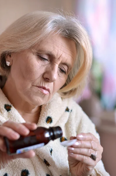 Oudere vrouw een geneesmiddel inneemt — Stockfoto