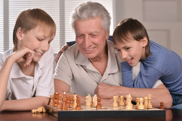 Två pojkar och farfar spelar schack — Stockfoto