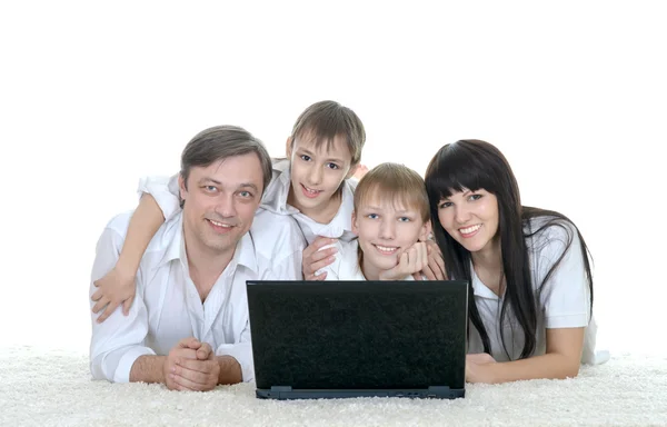 Familia descansando un ordenador portátil — Foto de Stock