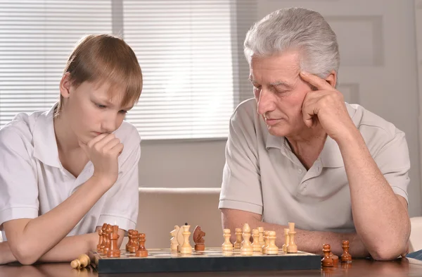 Мальчик и дедушка играют в шахматы — стоковое фото