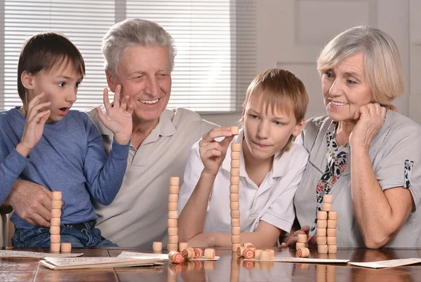 Två pojkar och farföräldrar spelar lotto — Stockfoto