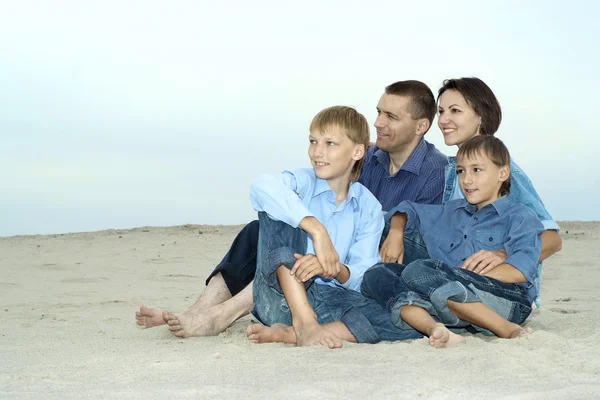 Familie zittend op het zand — Stockfoto