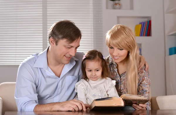 Genitori leggendo un libro la loro figlia — Foto Stock