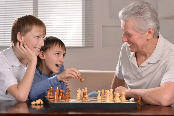 Счастливая семья за шахматами — стоковое фото