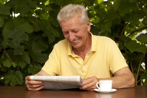 Θετική παλαιότερη άνθρωπος που κάθεται στη βεράντα — Φωτογραφία Αρχείου