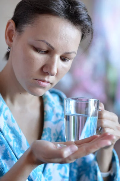 Young woman taking a medicine — Stock Photo, Image