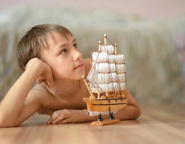 Liten pojke med en leksak-fartyg — Stockfoto