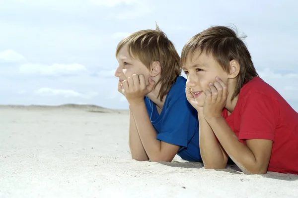 As crianças jazem na areia — Fotografia de Stock