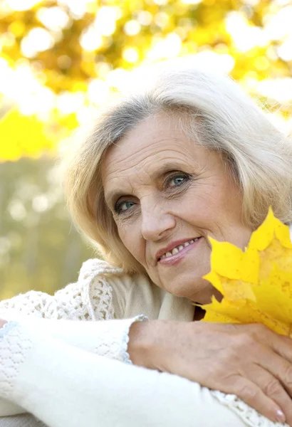 黄色の葉の背景に立っている女性 — ストック写真