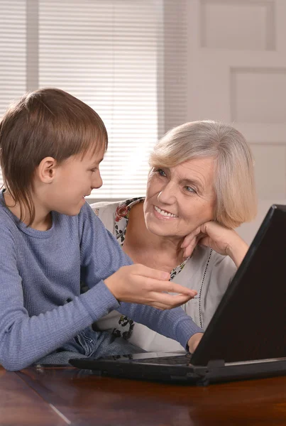 Jongen en grootmoeder met laptop — Stockfoto