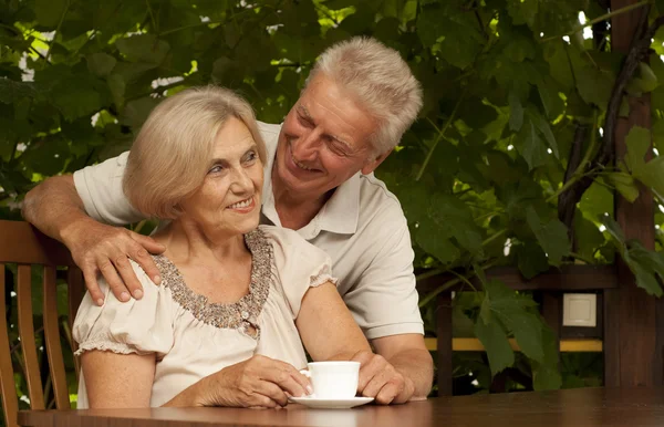 Glad older couple sitting on the veranda — Stock Photo, Image