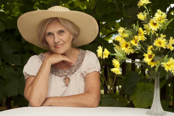 Beautiful older woman sitting on the veranda — Stock Photo, Image