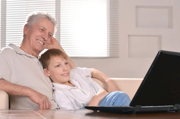 Jongen en zijn grootvader met een laptop — Stockfoto